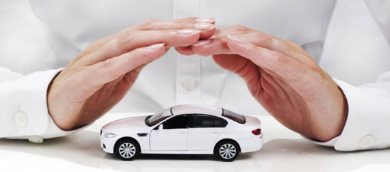 auto insurance - hands over a toy car protecting the car