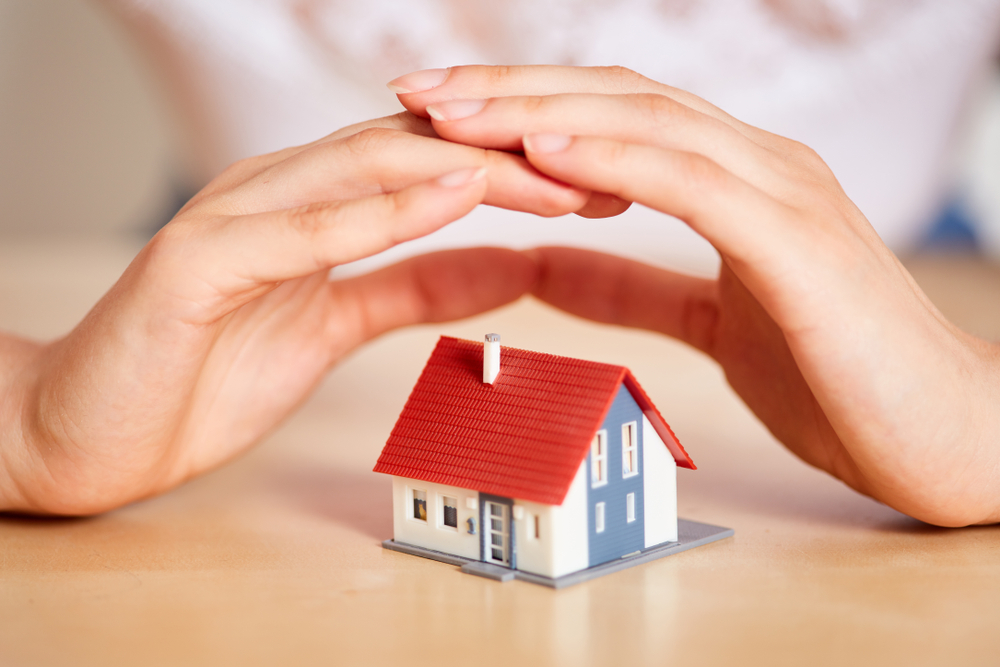 2 hands over a home for home insurance