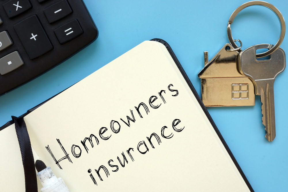 homeowners insurance paper with home key next to paper